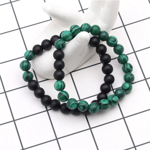 Détail de bracelets en perles d'agate noire mate et malachite verte de 8 mm sur un moule