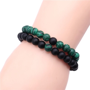 Détail de perles en pierre noire mate de 8mm et malachite verte sur un bracelet perlé