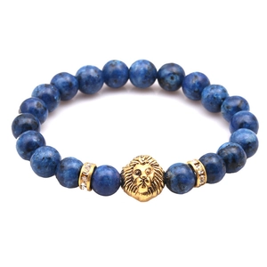 Detailed macro shot of blue marble beads with a golden lion head and rhinestone accents