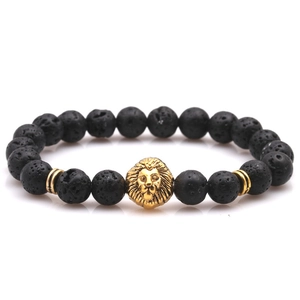Close-up of black volcanic lava stone beads with a golden lion head and metal spacers