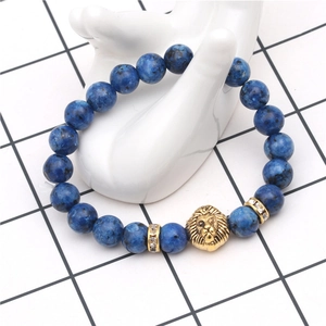 Macro shot of blue stone beaded bracelet featuring a gold lion head and crystal spacers