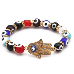 Détail de la Main de Fatima avec œil bleu et bracelet en perles colorées avec corde