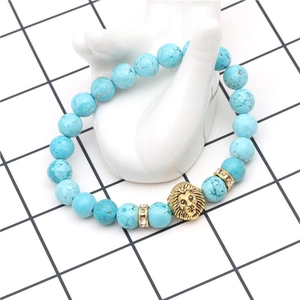Detail of blue turquoise bead bracelet with gold lion head and crystal spacers on hand