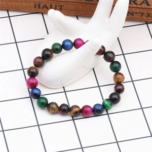 Macro detail of 8mm colorful tiger eye stone beaded bracelet on white ceramic hand stand