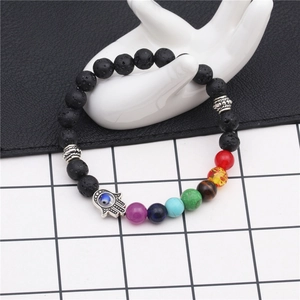 8mm lava stone hamsa hand bracelet with colorful chakra beads on a hand display
