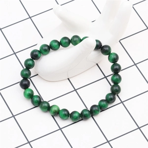Detail of 8mm green tiger eye beaded bracelet on white ceramic display stand