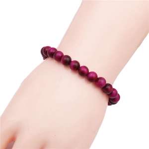 Detail of 8mm dark pink tiger eye beaded bracelet showing cat eye luster on wrist