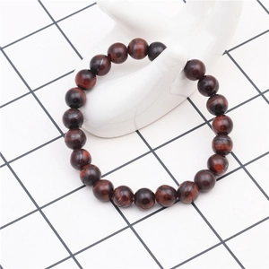 Detail of 8mm natural red tiger eye beaded bracelet showing fibrous texture on white display