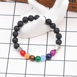 Detailed shot of 7 chakra lava stone bracelet on a white ceramic hand display