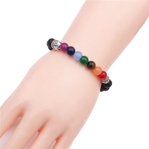 Detail of 8mm lava rock beads and silver Buddha head on a colorful chakra stone bracelet