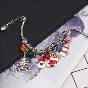 Détails d'un bracelet en chaîne serpent argentée avec breloques de Noël colorées