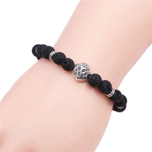 Men's lava stone beaded bracelet with silver lion head charm worn on a wrist