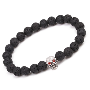 Detail of volcanic stone bracelet with zirconia skull and red gemstone eyes