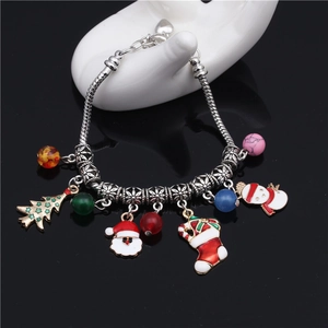 Vue macro du bracelet de Noël avec pendentifs Père Noël, sapin et perles colorées