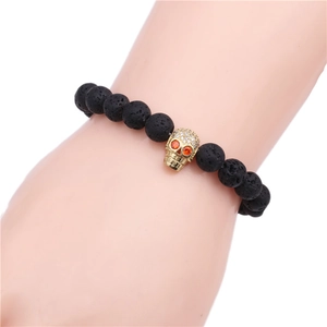 Lava stone bead bracelet with a gold-plated skull charm featuring micro-set cubic zirconia