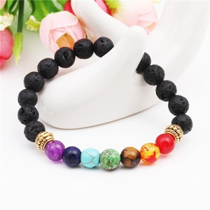 7 Chakra lava rock bead bracelet with golden spacers on a white hand display