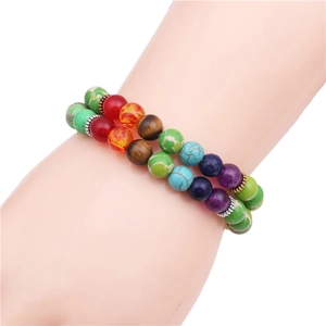 Bracelet double couche en perles de chakra naturelles porté au poignet d'une femme