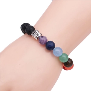 Bracciale 7 chakra in pietra lavica con testa di Buddha d'argento al polso, sfondo bianco