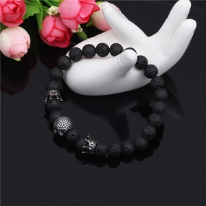 Detail of 8mm black lava stone crown bracelet with a sparkling crystal skull charm