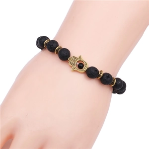 8mm black lava stone beaded bracelet with golden Hamsa Hand charm on male wrist