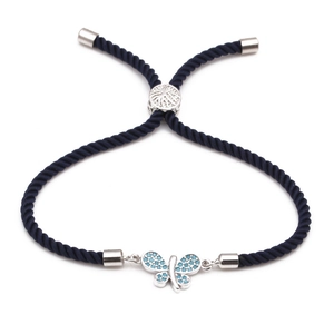 Adjustable blue woven bracelet featuring a silver butterfly charm with blue zircon stones