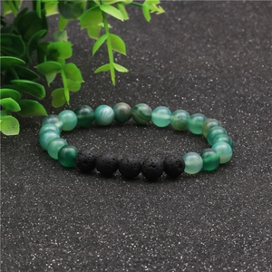 Detalle macro de cuentas de ágata a rayas verdes y piedra de lava negra de 8mm en pulsera