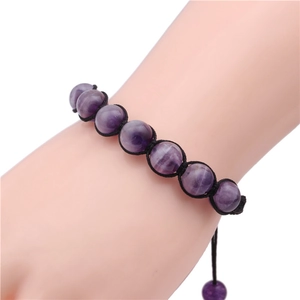 Detail of 10mm amethyst beaded bracelet with black woven cord on woman's wrist