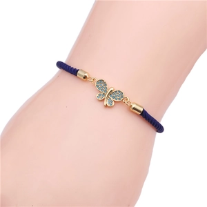 Detail showing deep blue braided rope bracelet with a gold-plated blue butterfly charm