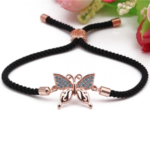 Detail of hand-woven black cord bracelet with rose gold zircon butterfly charm