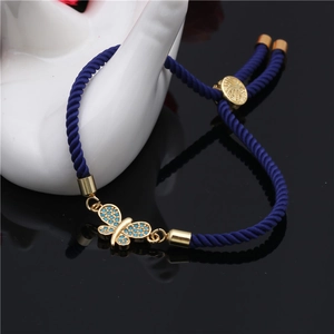 Detail of adjustable blue woven rope bracelet with gold butterfly and zircon inlay