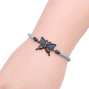 Close-up of adjustable butterfly charm bracelet with turquoise micro-pave stones on blue cord