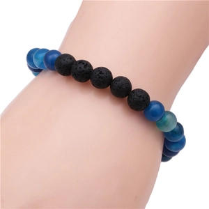Detalle de la pulsera de cuentas de ágata azul de 8mm y piedra de lava en el brazo