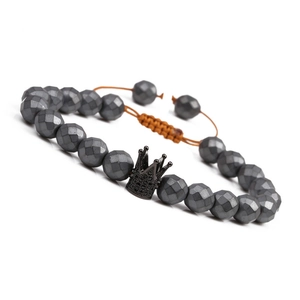 Detail of faceted hematite beads and a black crown charm on an adjustable bracelet