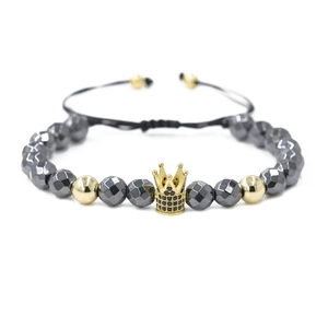 Detail of beaded bracelet with black hematite facets and gold zircon crown charm