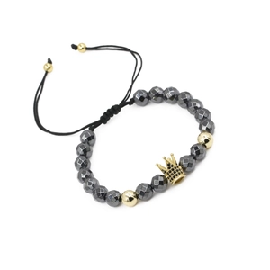 Detailed macro of golden crown charm with micro-pavé black crystals on hematite beads