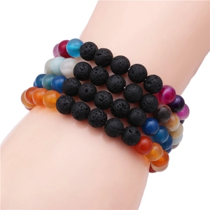 Primer plano de pulseras de piedra volcánica de 8mm y ágata de colores en una muñeca