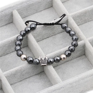 Detail of beaded bracelet with black crown charm and faceted magnetic stones