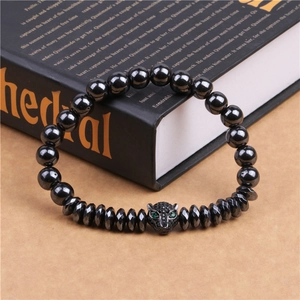 Detail of beaded hematite bracelet featuring a black leopard head with green stone eyes