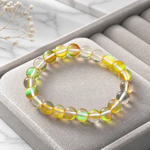 Détail d'un bracelet en pierre de lune avec reflet bleu sur un présentoir à main blanc