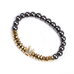Macro detail of hematite bead bracelet featuring a gold crown set with micro zircons
