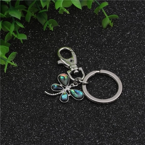 Detailed macro view of dragonfly keychain with colorful abalone shell inlay and rhinestones