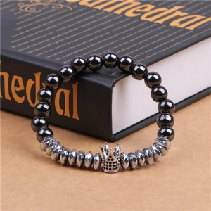 Detail of beaded bracelet showing hematite beads and micro-pave zircon crown on a book