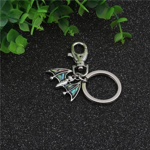 Macro view of silver bat keychain with colorful abalone shell inlay wings