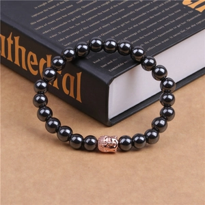 Close-up of black beaded magnetic bracelet with a rose gold Buddha head charm detail