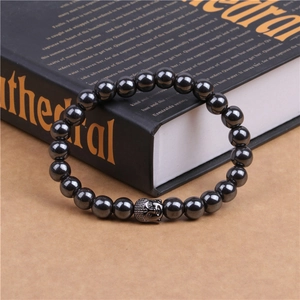 Macro view of magnetic hematite beaded bracelet with a metallic Buddha head charm