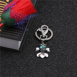Detailed koi fish keychain with iridescent abalone shell inlay on black background
