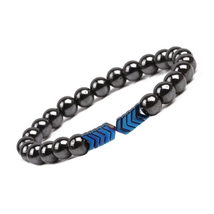 Macro shot of magnetic hematite beads and blue arrow-shaped charms on copper bracelet