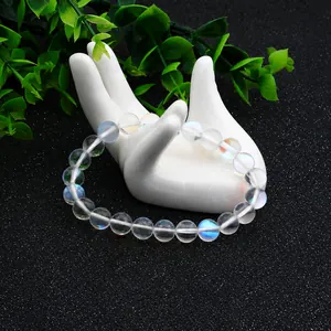 Gros plan d'un bracelet en perles de pierre de lune avec reflets bleus sur support blanc