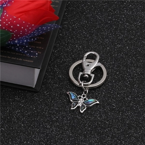 Detailed macro shot of silver butterfly keychain with iridescent abalone shell inlay
