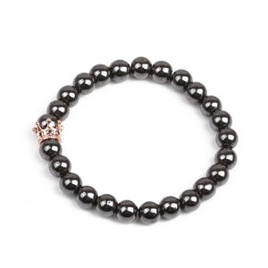 Detailed close-up of magnetic hematite beads with a rose gold micro-pave crown charm